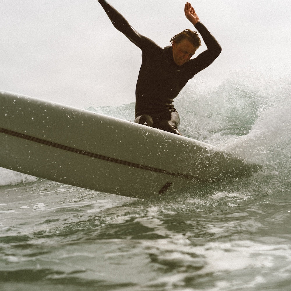 Person surfing on a wave with arms raised
