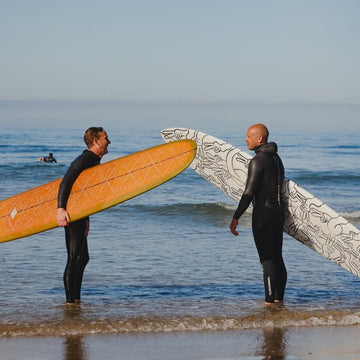 Two surfers with their boards on a beach