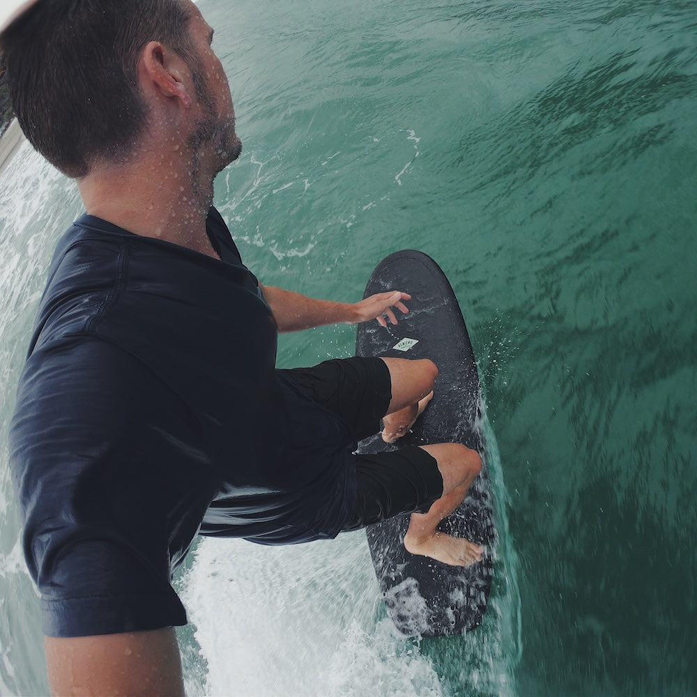 man riding black surfboard