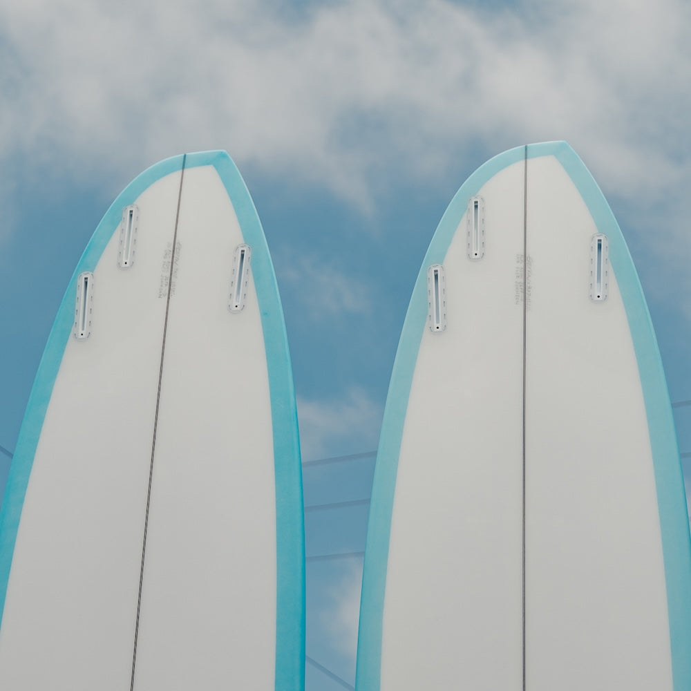 Two surfboards with blue tops against a cloudy sky