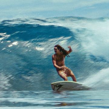 Person surfing on a large wave in the ocean