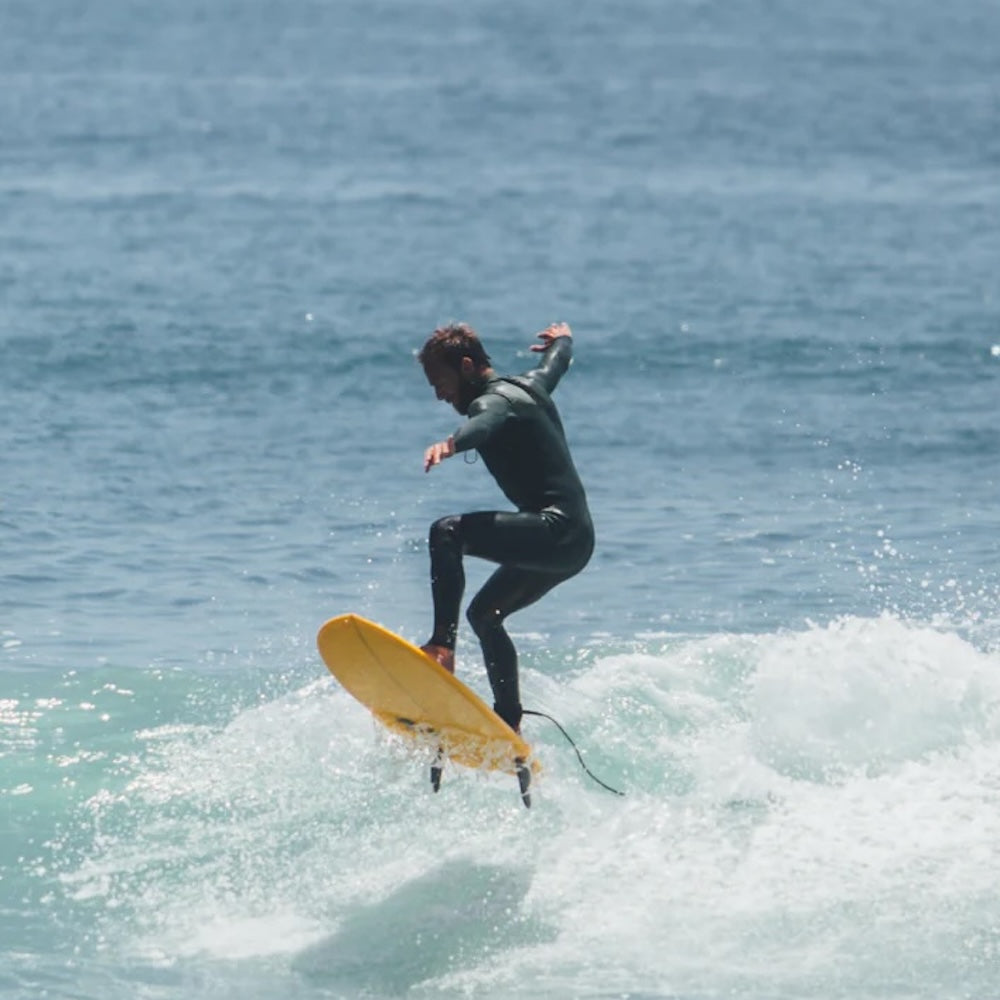 Person surfing on a yellow board in the ocean