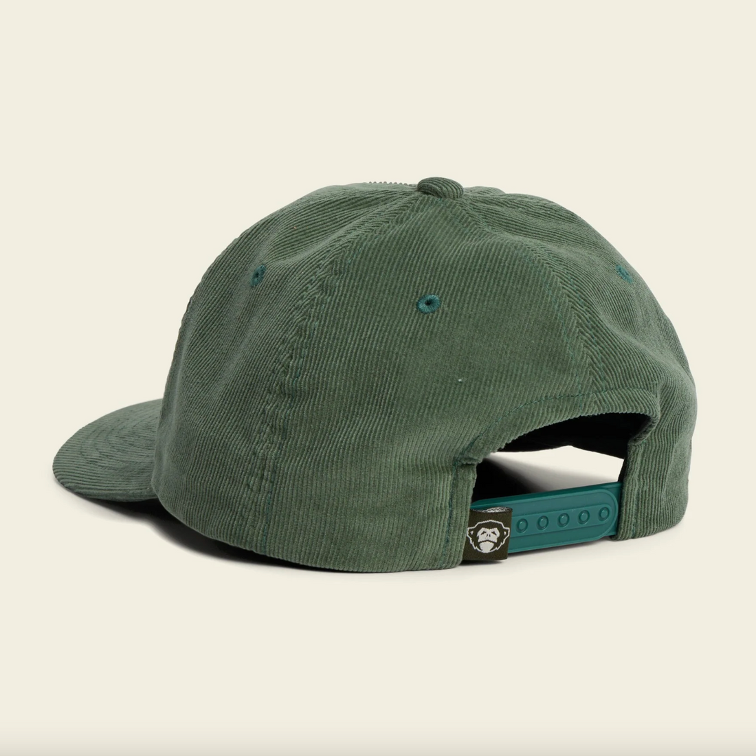 Green cap with 'Howler' logo on a beige background