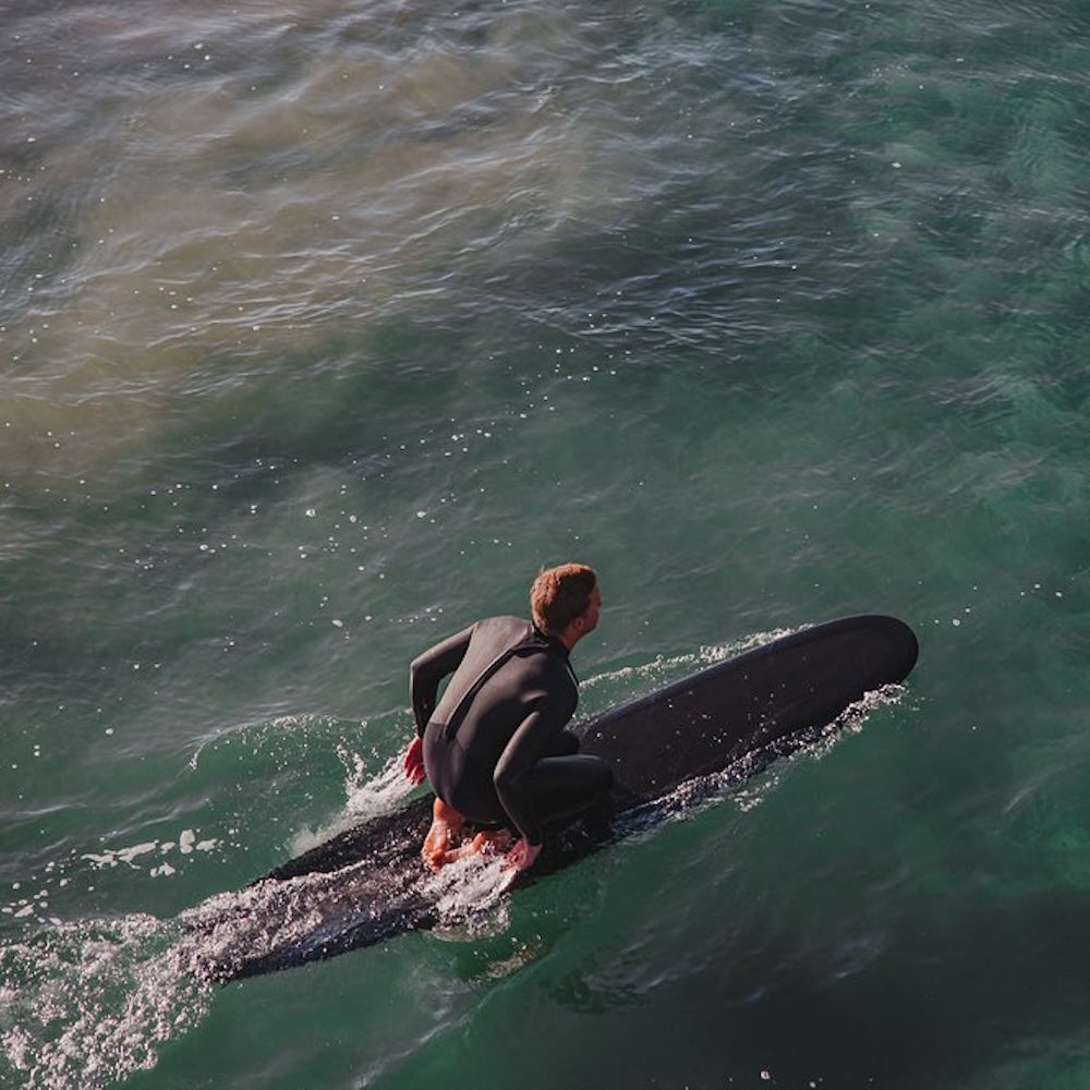 Person in a wetsuit on a surfboard in the ocean