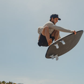 Person performing a skateboarding trick against a clear sky