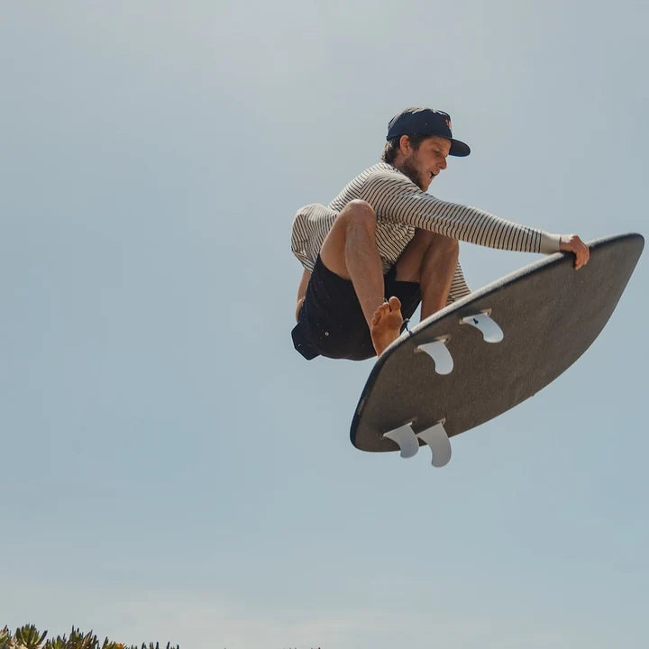 Person on a surfboard against a clear sky