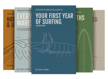 Collection of Almond Surfboards guide books on a white background