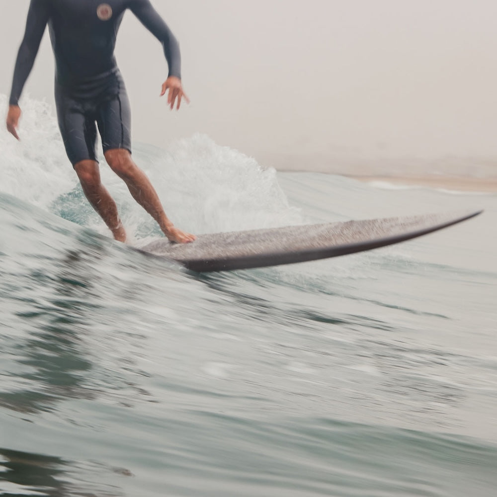 Person surfing on a wave wearing a wetsuit