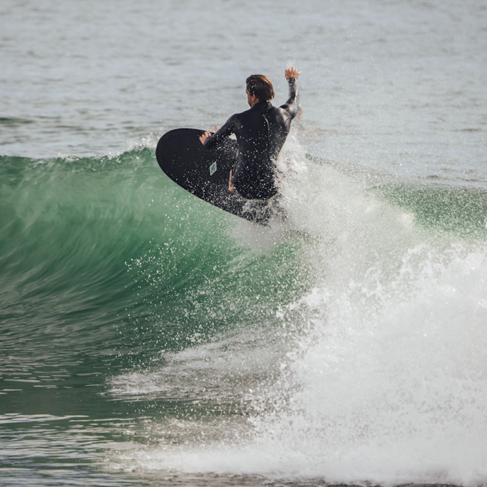 Person surfing on a wave in a wetsuit
