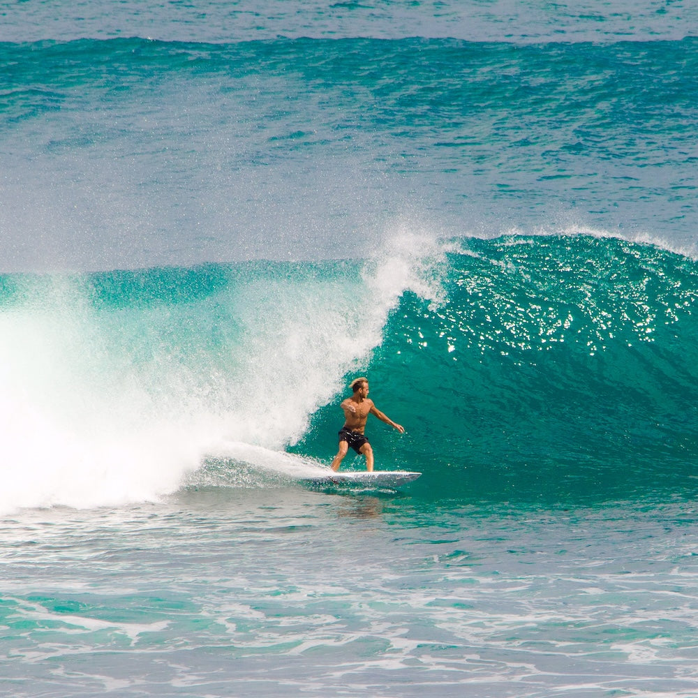 Person surfing on a large wave in the ocean