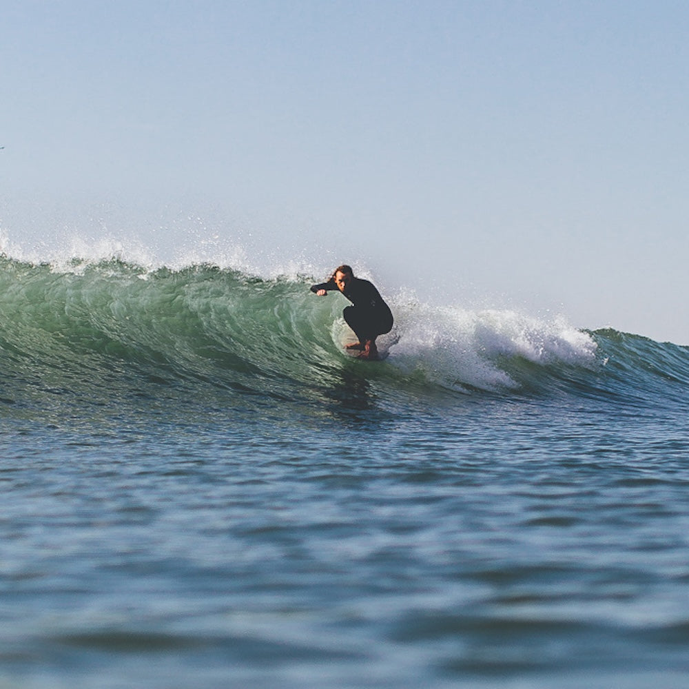 Person surfing on a wave with clear sky