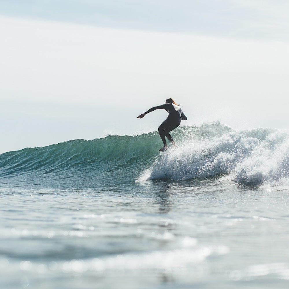 Person surfing on a wave with clear sky