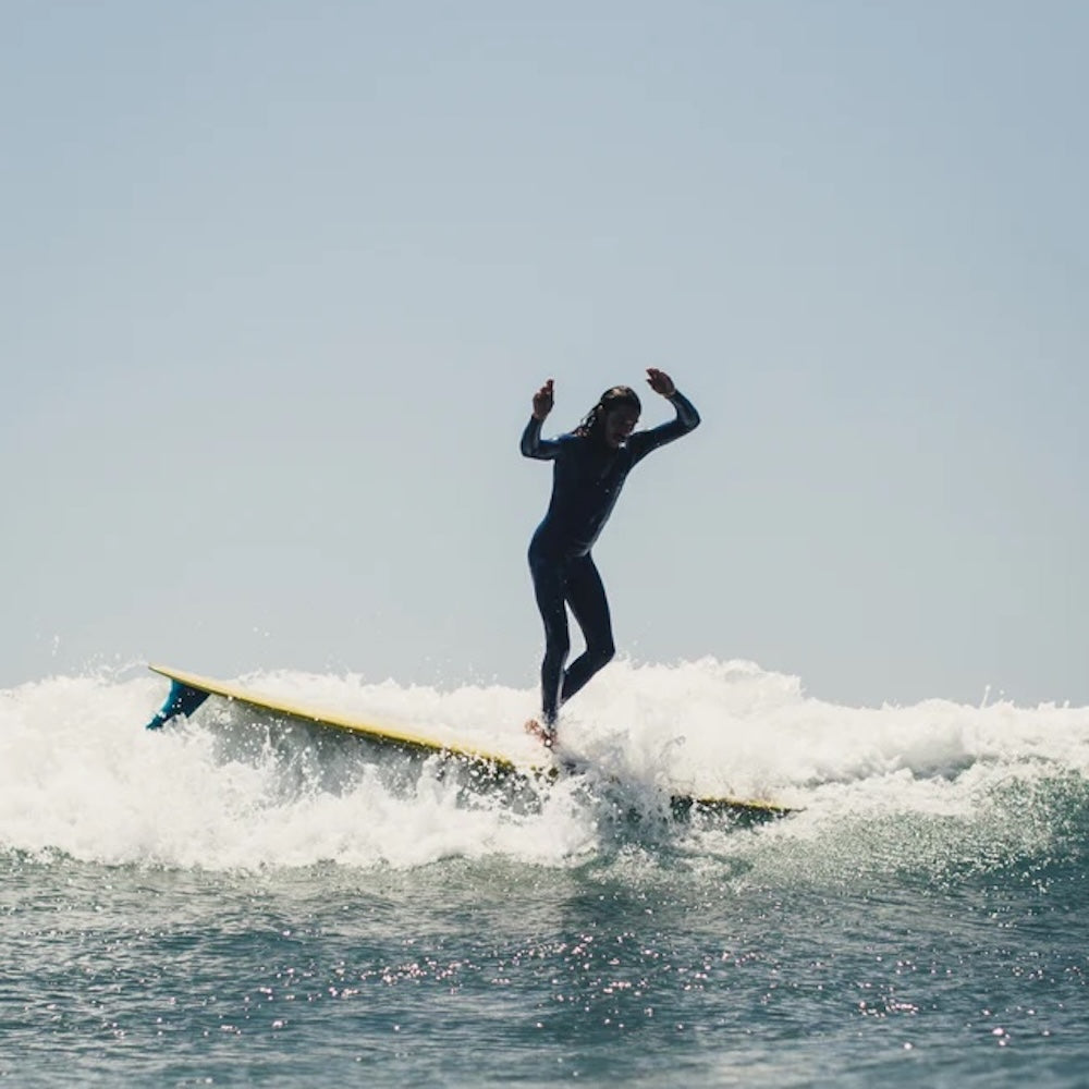 Person surfing on a wave with clear sky